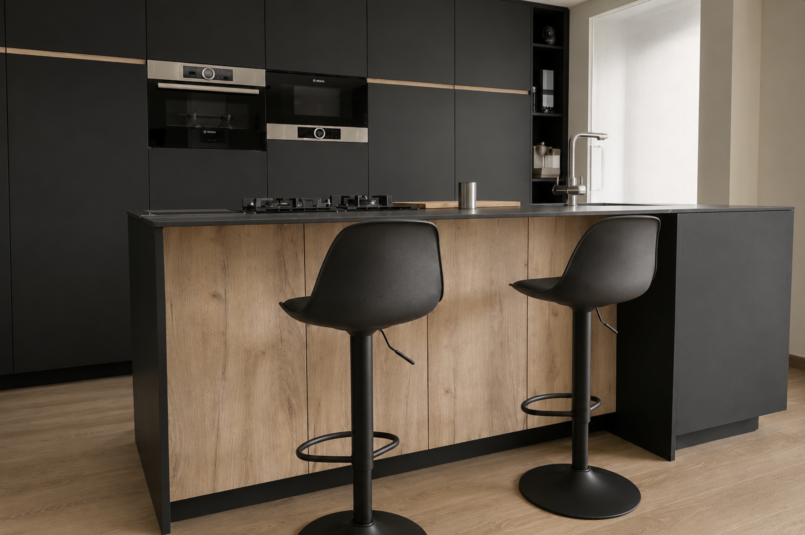 Negro y madera. La península combina una encimera oscura con un frente de madera. Dos taburetes convierten este lado de la cocina en un lugar donde sentarse.