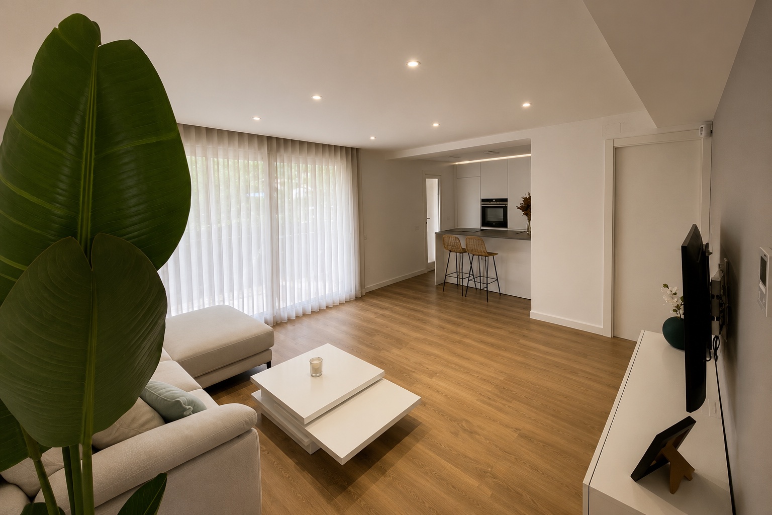 Abierta al salón. La cocina se abre a una zona de estar con suelo de madera. La distribución permite compartir el espacio sin renunciar a cada ambiente.